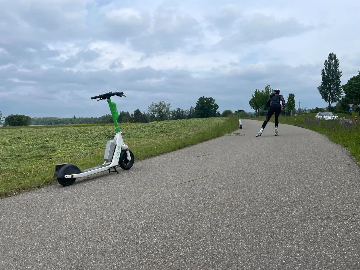 Zwei E-Trottinette der Marke Lime stehen am Strassenrand.